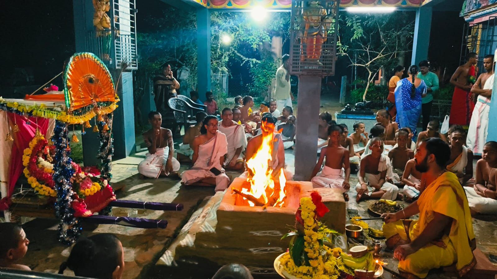 Students and priests gathered around a sacred fire during a Vedic ritual