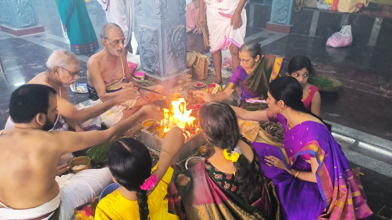Women and men making offerings at a sacred fire